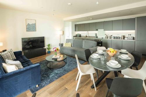 a living room with a blue couch and a table at Bermondsey Apartments By Sleepy Lodge in London