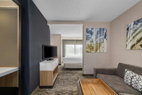 a living room with a couch and a flat screen tv at SpringHill Suites Minneapolis West St. Louis Park in Saint Louis Park