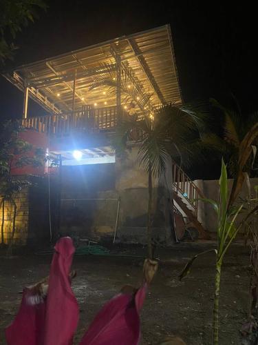 a person laying down in front of a house at night at Arsilahomestay in Tetebatu
