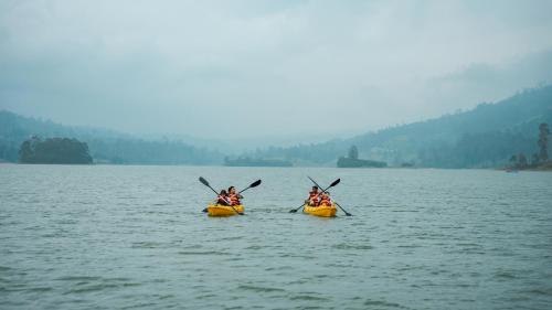 two people are in kayaks on a lake at Ceylon Tea Trails - Relais and Chateaux - All Inclusive in Hatton