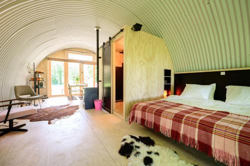 een slaapkamer met een bed en een hond die op de vloer ligt bij Het Lage Noorden in Marrum