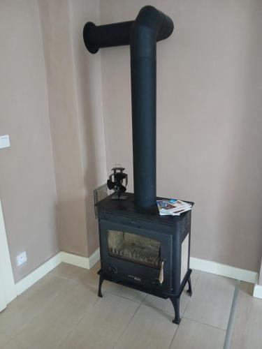 a black stove sitting in a corner of a room at Apartman Barrington in Žinkovy