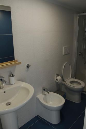 a white bathroom with a sink and a toilet at B&B Anema'e Core in Gaeta