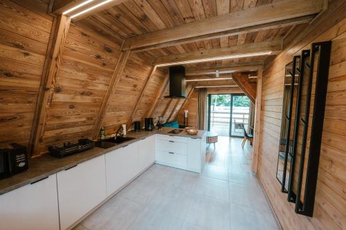 cocina con armarios blancos y paredes de madera en Ośrodek Wypoczynkowy Nad Leśną Wodą, en Bystrzyca