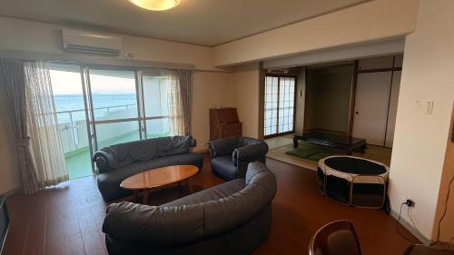 a living room with a couch and a table at Went Members only Resort Condominium in Sumoto