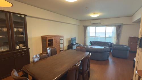 a living room with a wooden table and a couch at Went Members only Resort Condominium in Sumoto