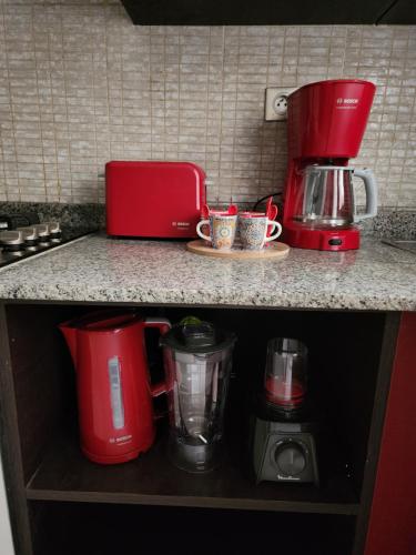 a kitchen counter with red appliances on a counter top at Anis Home in Agadir