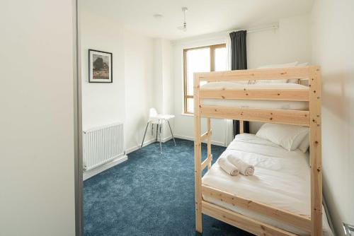 a bedroom with a bunk bed and a window at Bermondsey Apartments By Sleepy Lodge in London