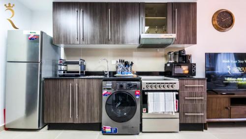 a kitchen with a washer and a refrigerator at Cozy Urban Studio - Peach Bliss Haven in Abu Dhabi