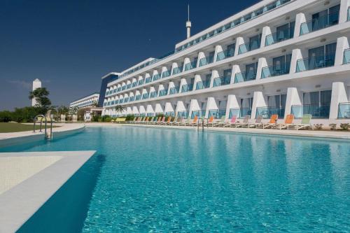 a hotel with a swimming pool in front of a building at Four Points by Sheraton Costa Blanca Resort in Benidorm