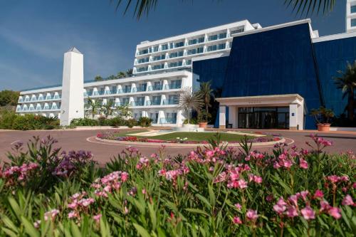 a large building with pink flowers in front of it at Four Points by Sheraton Costa Blanca Resort in Benidorm