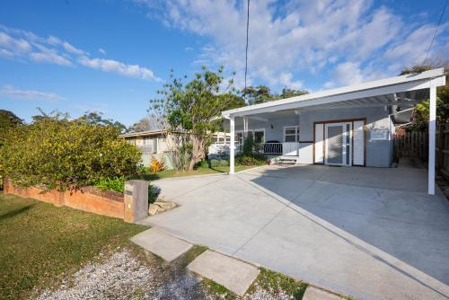 a white house with a driveway at Magnolia Homestead in Coffs Harbour