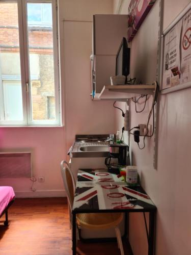 a kitchen with a sink and a table with chairs at Studio Girodeau Moulins in Moulins