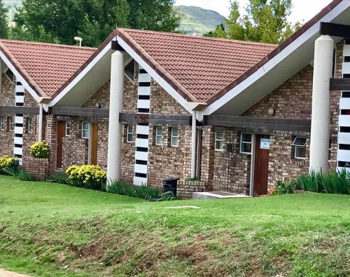 een stenen huis met een rood dak bij Studio 28 Clarens, Apartment A in Clarens