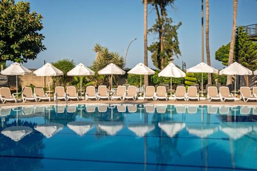 a swimming pool with chairs and umbrellas at Hotel Grand Kaptan - Ultra All Inclusive in Alanya