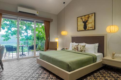 a bedroom with a bed and a balcony at River Estates Resort, Restaurant & Spa by Vibescapes in Karjat