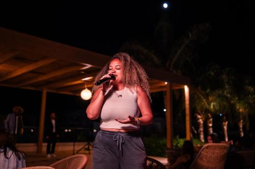 a woman with long hair singing into a microphone at Sentido Kyknos Beach Adults Only in Malia