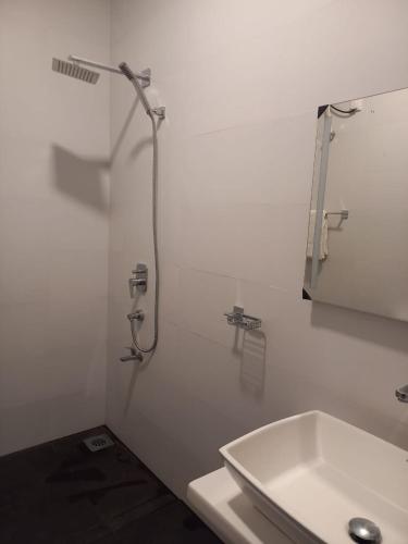 a white bathroom with a shower and a sink at The Trees Dambulla in Dambulla
