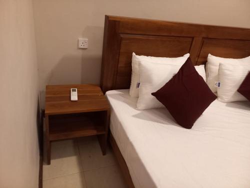 a hotel room with a bed and a night stand at The Trees Dambulla in Dambulla