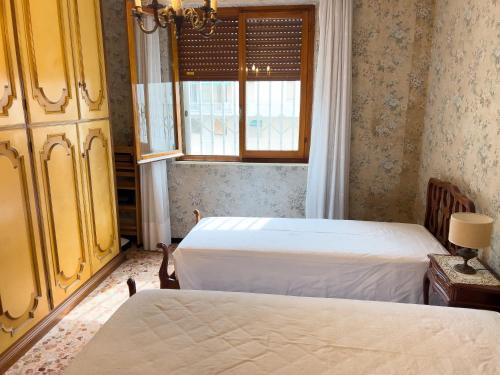 een slaapkamer met twee bedden en een raam bij Casa Francy - Taggia in Arma di Taggia
