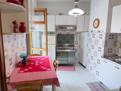 een keuken met een tafel met een rode tafellaken bij Casa Francy - Taggia in Arma di Taggia