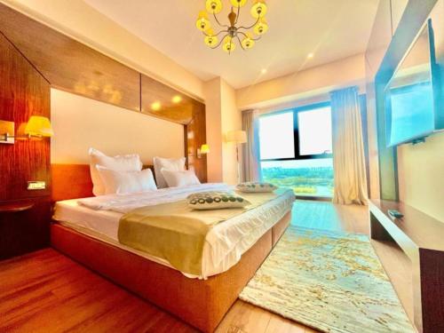 a bedroom with a large bed and a large window at YamaLuxe Luxury Apartments - București in Bucharest