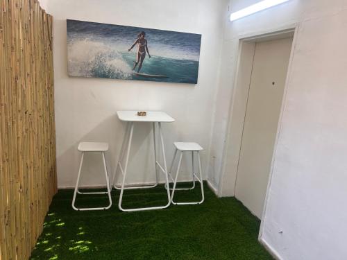 a room with two stools and a picture of a surfer at בית הקונגרס גבעת אולגה in H̱adera