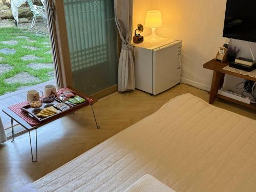 a living room with a table and a refrigerator at Pungnam House in Jeonju