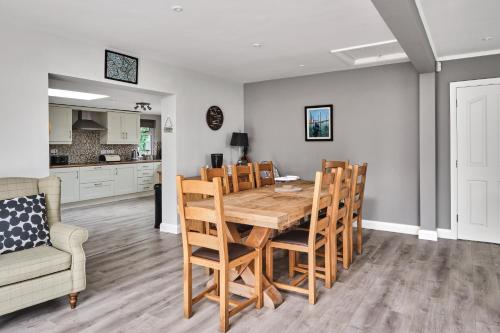 a kitchen and dining room with a wooden table and chairs at Loughside Lodge - Fermanagh 5 bed waterside bungalow in Culky