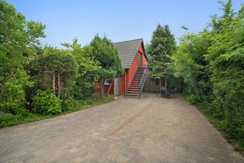 a brick road leading to a red house at Storchensommer in Blankensee