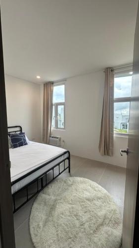 ein Schlafzimmer mit einem Bett, einem Teppich und einem Fenster in der Unterkunft Serenity Bliss Townhouse in Aga
