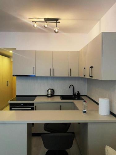 a kitchen with white cabinets and a sink and a counter at YamaLuxe Luxury Apartments - București in Bucharest