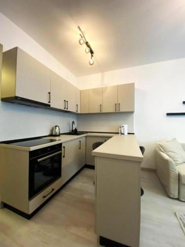 a kitchen with white cabinets and a stove top oven at YamaLuxe Luxury Apartments - București in Bucharest