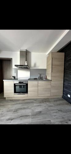 a large kitchen with wooden cabinets and a stove at Les Ailes de Morphée in Villé