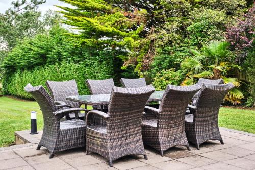 a group of wicker chairs and a table on a patio at Loughside Lodge - Fermanagh 5 bed waterside bungalow in Culky