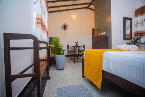 a room with a bed and a table and chairs at Vibe green villa in Unawatuna