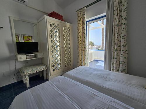 una camera da letto con un letto, una tv e una finestra di Aguazul-323 a Tías