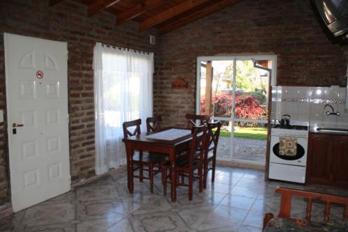Una cocina con una mesa y sillas en una habitación. en Cabañas Don Mario, en Sierra de la Ventana