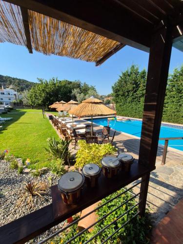 a patio with a group of tables and umbrellas at Maritina Apartments in Ixia