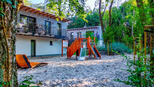 a playground in front of a house with at Baltic Forest in Kołobrzeg