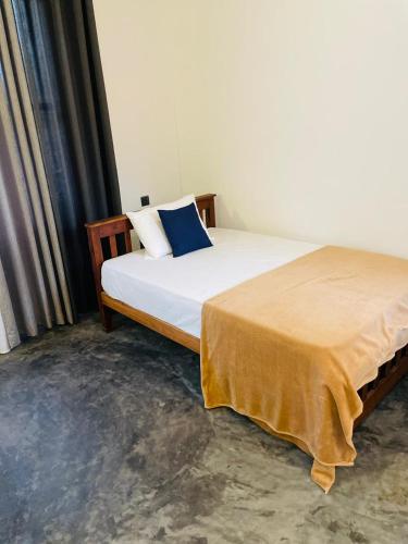 a bedroom with a bed with a yellow blanket on it at Sea Wawes Hiriketiya in Hiriketiya