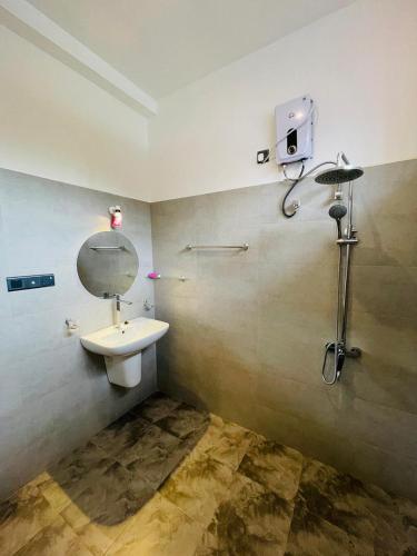a bathroom with a sink and a mirror on the wall at Sea Wawes Hiriketiya in Hiriketiya
