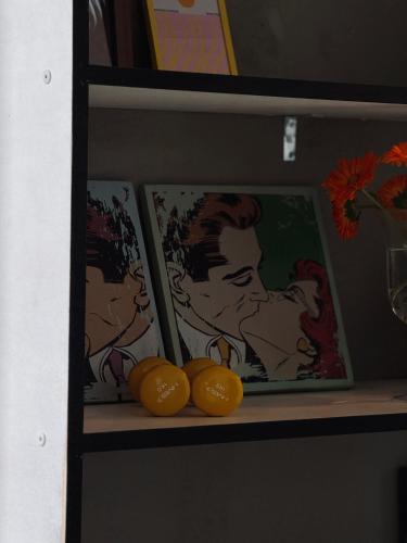 a shelf with paintings and some lemons on it at ArtLoft Ikšķile in Ikšķile
