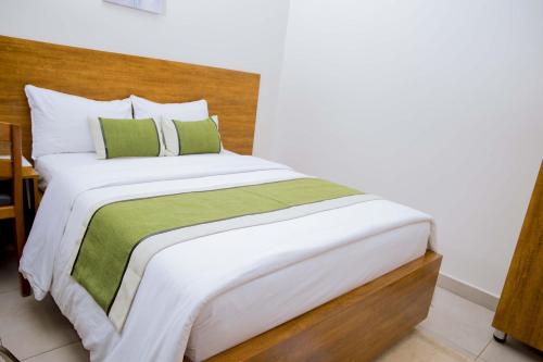 a bedroom with a large bed with a wooden headboard at Velvet Suites in Kigali