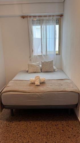 ein Bett in einem Schlafzimmer mit einem großen Fenster in der Unterkunft Apartamento entero Playa Perello Valencia in El Perelló