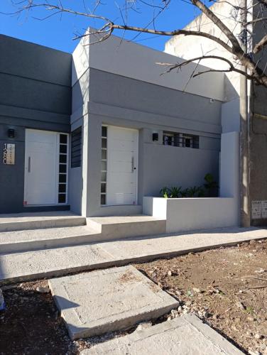 ein weißes Haus mit zwei weißen Türen und Treppe in der Unterkunft Departamentos San Martin in San Pedro