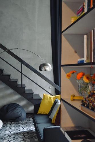 a living room with a blue couch and a staircase at ArtLoft Ikšķile in Ikšķile