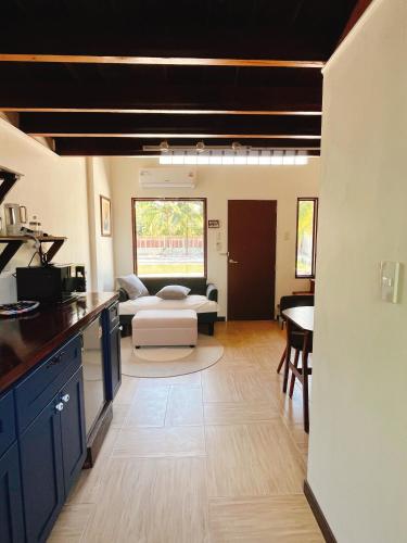 a kitchen and living room with a couch and a table at Phimai Pond House in Phimai