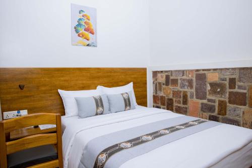 a bedroom with a bed and a wooden headboard at Velvet Suites in Kigali