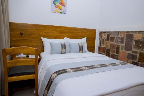 a bedroom with a bed and a wooden headboard at Velvet Suites in Kigali